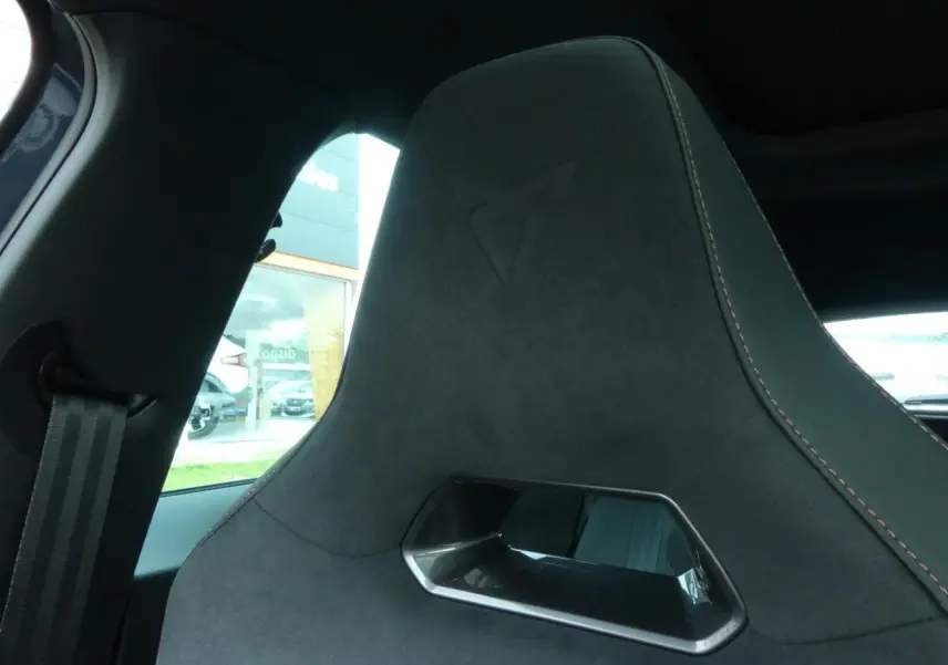 Détail du siège baquet noir suédine avec surpiqûres cuivrées et logo Cupra embossé, intérieur du Formentor gris graphene.