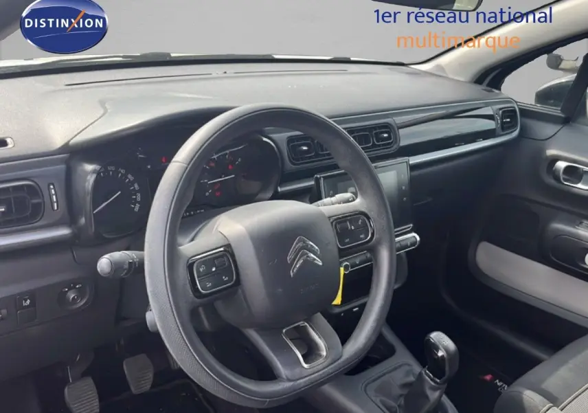 Intérieur de la Citroën C3 2018 vu côté conducteur, tableau de bord noir avec volant multifonction et boîte manuelle.