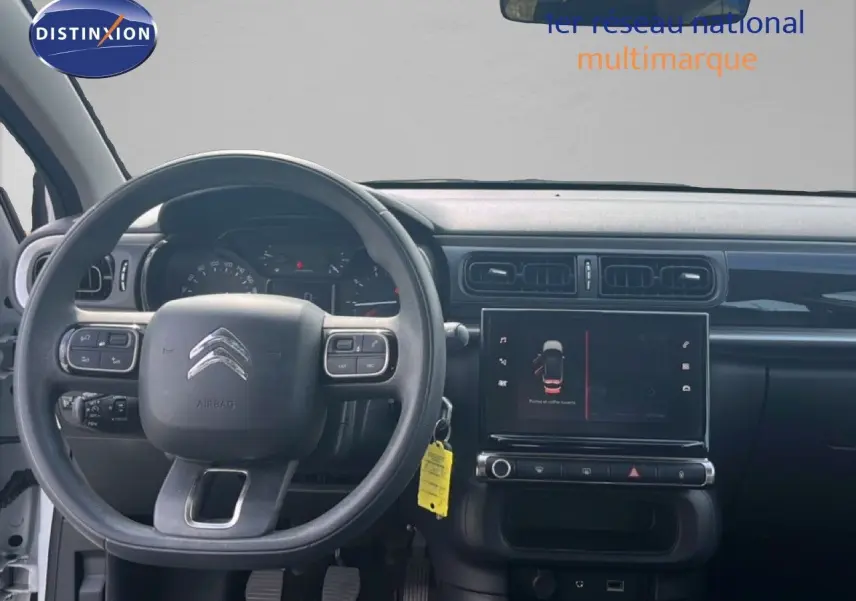 Vue intérieure centrée sur le volant et le tableau de bord de la Citroën C3 blanche, version PureTech 2018.