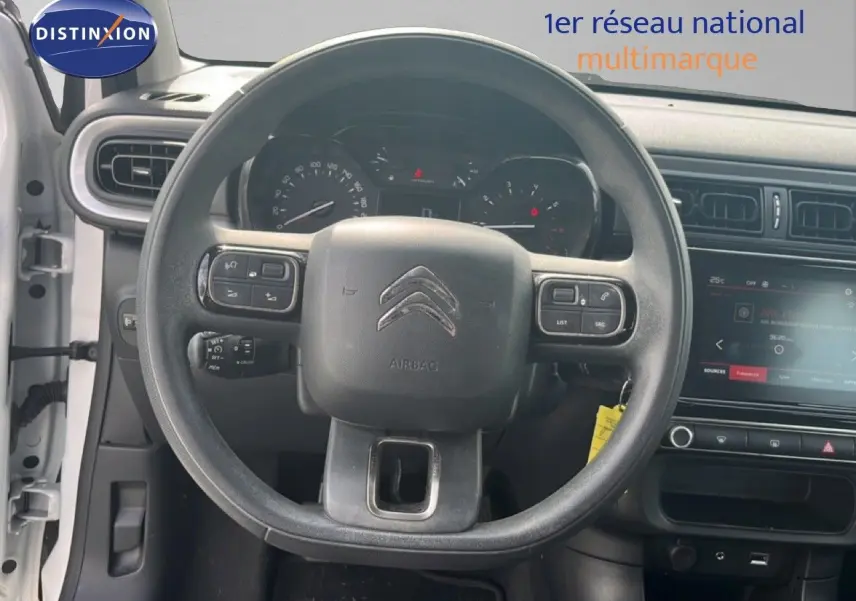 Vue intérieure centrée sur le volant de la Citroën C3 blanche de 2018, avec tableau de bord et écran tactile visibles.