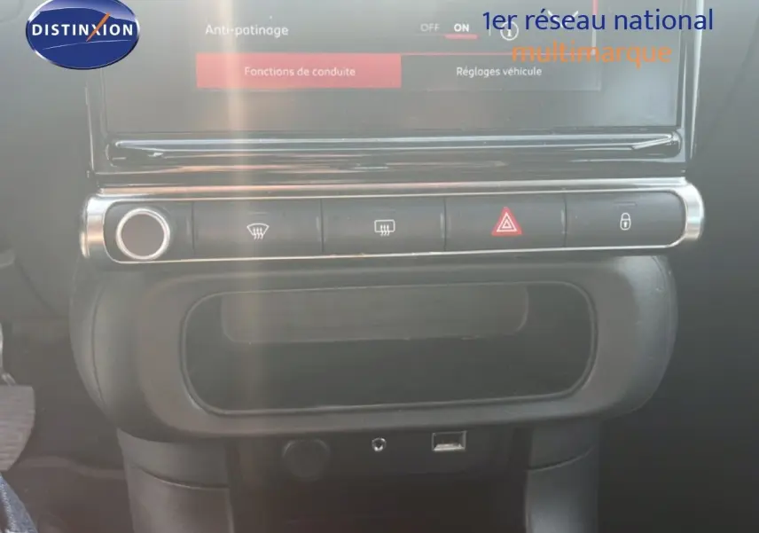 Détail de la console centrale noire de la Citroën C3 blanche 2018 avec boutons de commande et écran tactile.