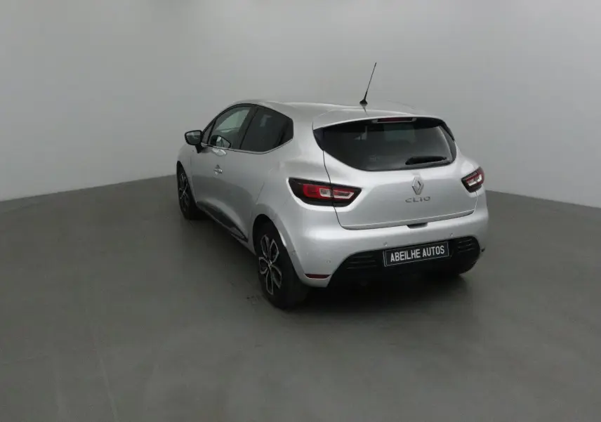 Vue 3/4 arrière droite d'une Renault Clio IV gris clair métal avec jantes biton et feux arrière LED distinctifs.