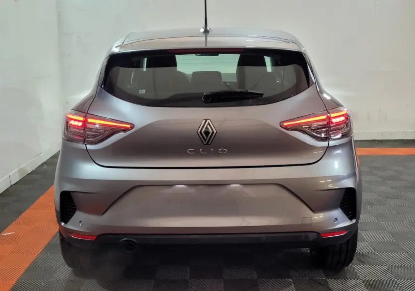 Vue arrière d'une Renault Clio gris foncé avec feux LED allumés dans un garage intérieur.