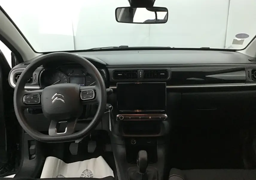 Vue frontale de l’intérieur noir de la Citroën C3 2022 avec volant multifonction et écran tactile central.