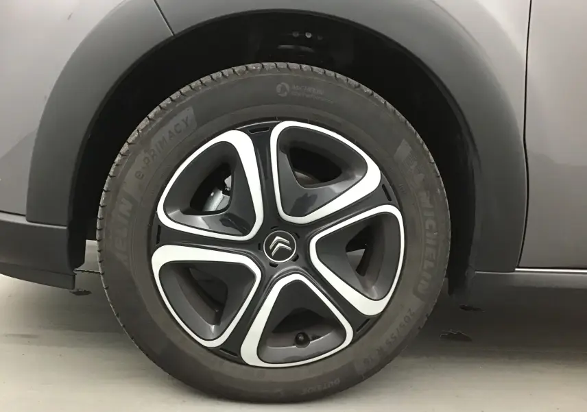 Gros plan sur la roue arrière droite d'une Citroën C3 gris platinium avec passage de roue noir mat.