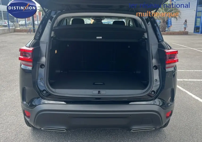 Vue arrière d'un Citroën C5 Aircross noir métal 2025 avec coffre ouvert et feux arrière allumés.