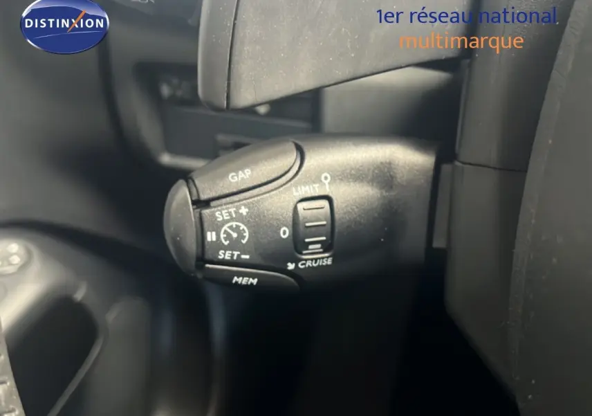 Gros plan sur la commande de régulateur de vitesse du Citroën C5 Aircross noir métal, côté gauche du volant.