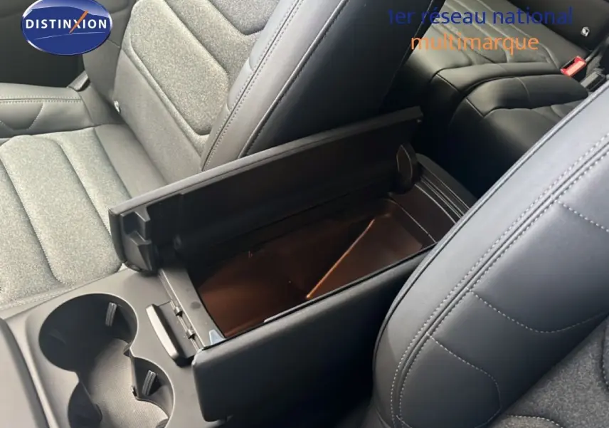 Vue intérieure rapprochée du coffre central ouvert entre les sièges avant en tissu gris et cuir noir du Citroën C5 Aircross 2025.