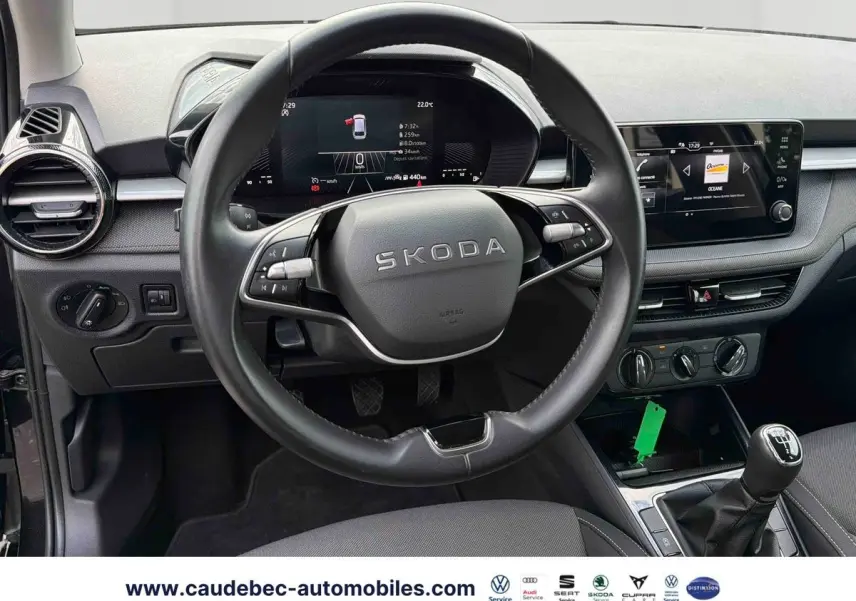 Vue intérieure centrée sur le volant cuir multifonctions SKODA Fabia 2025 avec écran digital et levier de vitesse manuel.