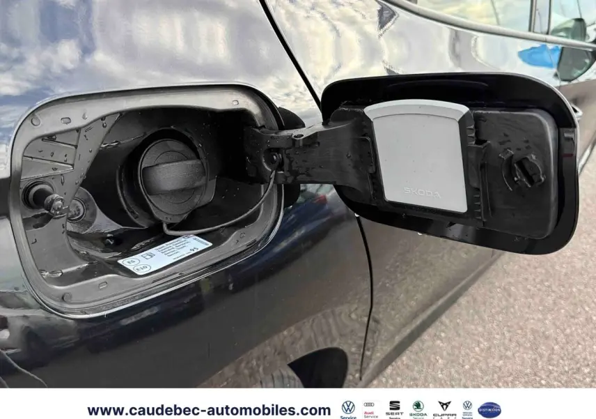 Trappe à carburant ouverte côté gauche d'une Skoda Fabia noire 2025, avec bouchon essence visible.