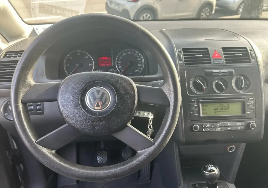 Vue intérieure du tableau de bord et volant noir d'un Volkswagen Touran 1.9 TDI 2004 avec boîte manuelle et radio intégrée.