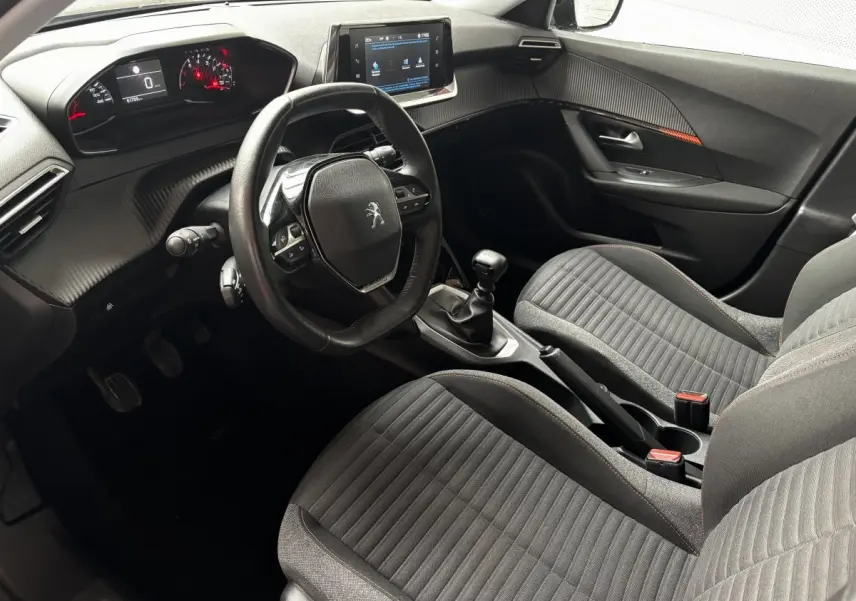 Intérieur avant droit du Peugeot 2008 noir 2021, volant cuir, tableau de bord numérique et écran tactile central visible.