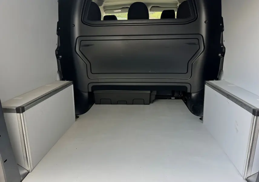 Vue intérieure de la zone de chargement du Peugeot Expert cabine approfondie gris, avec séparation noire et plancher clair.