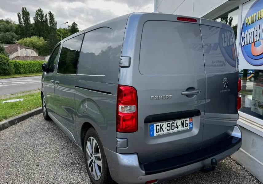 Vue 3/4 arrière droite d'un Peugeot Expert gris 2022 stationné, avec feux rouges et plaque d'immatriculation visible.