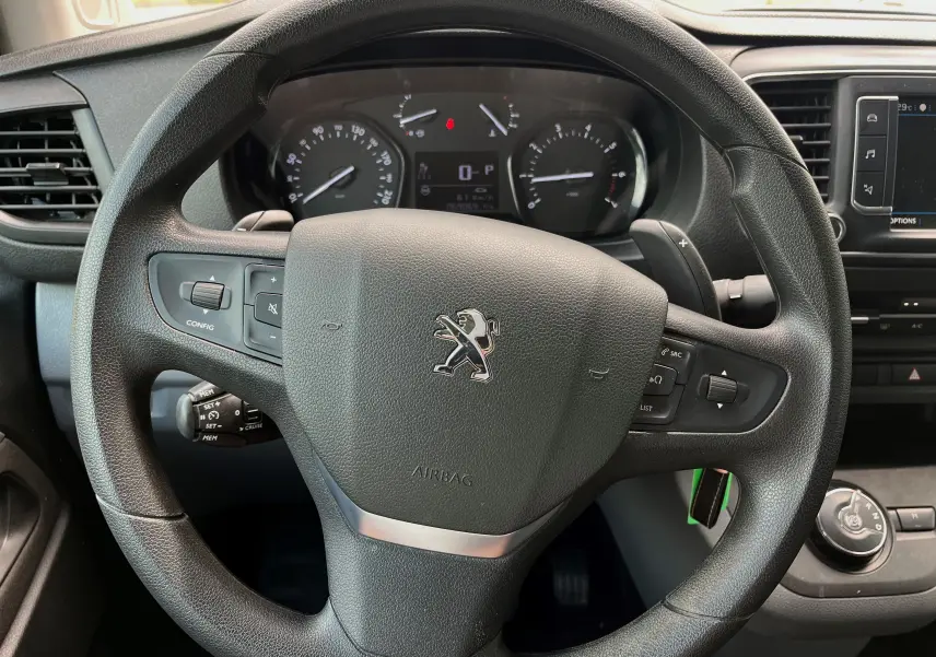 Vue rapprochée du volant noir du Peugeot Expert 2022 avec tableau de bord et commandes intégrées visibles.