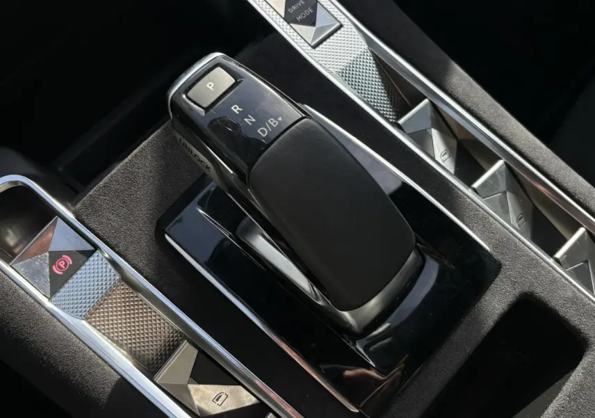 Gros plan sur la console centrale noire du DS7 1.6 E-Tense 225, avec levier de vitesses et commandes en aluminium.