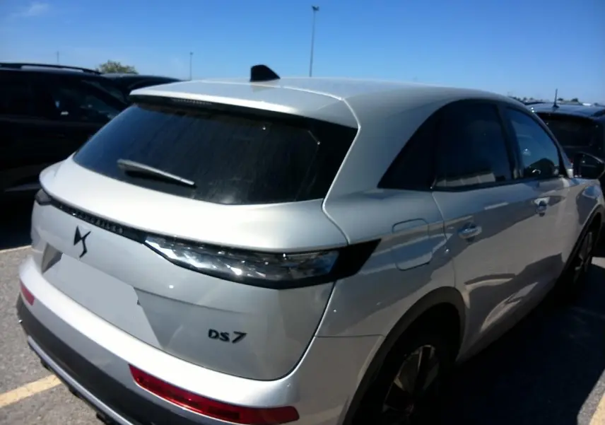 Vue 3/4 arrière droite du DS7 2024 Cristal Pearl avec feux arrière 3D et vitres surteintées.