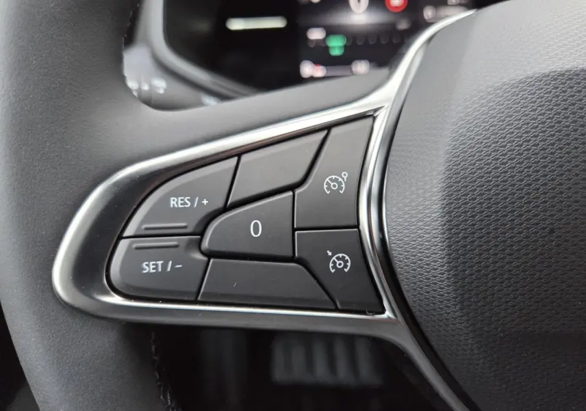Gros plan sur les commandes de régulateur de vitesse au volant noir de la Renault Clio V Gris Schiste 2025.