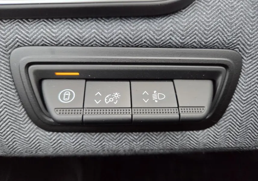 Gros plan sur les boutons de réglage d’éclairage et de vitesse sur la planche de bord grise d’une Renault Clio 2025.