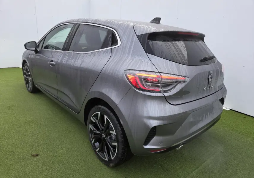 Vue 3/4 arrière droit d'une Renault Clio 2025 gris schiste métal avec jantes alliage noires et vitres surteintées.