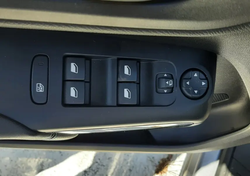 Gros plan sur les commandes de lève-vitres et réglage des rétroviseurs côté conducteur d'une Citroën C5 Aircross gris acier 2024.