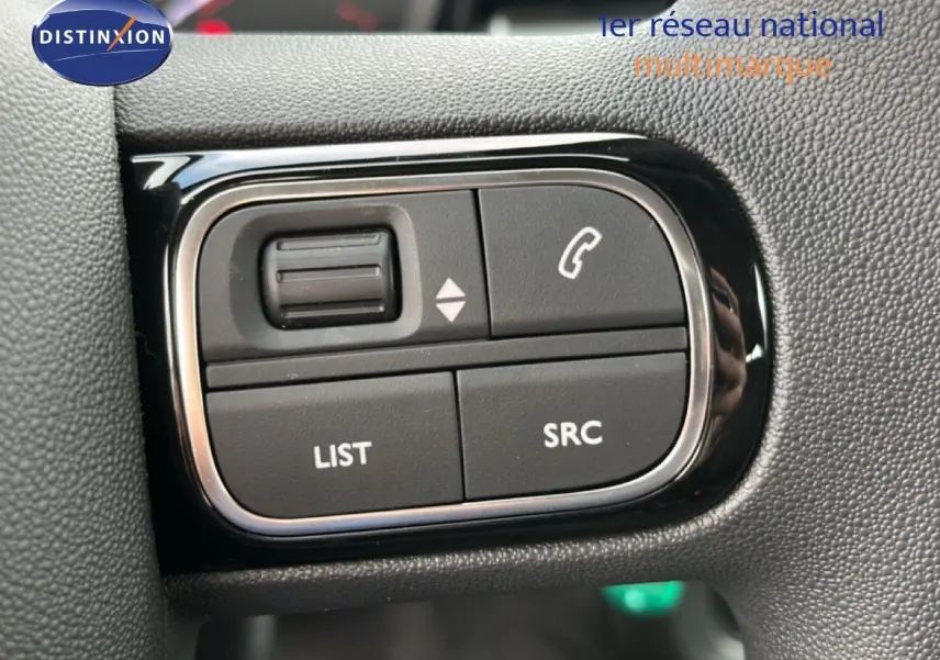 Gros plan sur les commandes au volant du Citroën C3 1.2 PureTech 82ch Plus, finition tissu gris/noir, 2024.