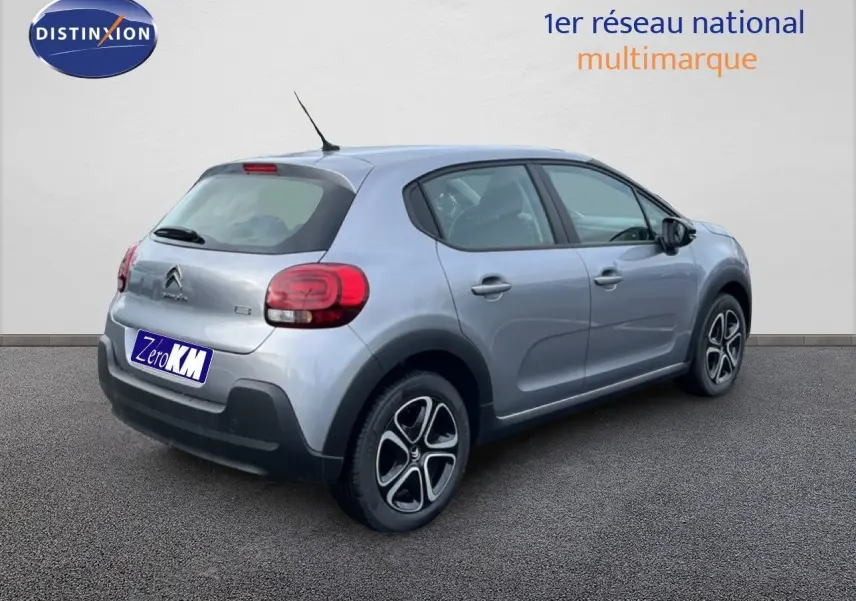 Vue 3/4 arrière droite d'une Citroën C3 2024 gris Artense métal avec feux arrière arrondis et jantes noires.