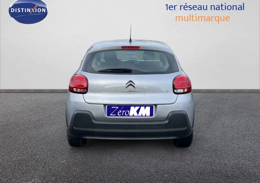 Vue arrière d'une Citroën C3 2024 gris Artense métal avec feux arrière arrondis et plaque d'immatriculation "Zéro KM" visible.