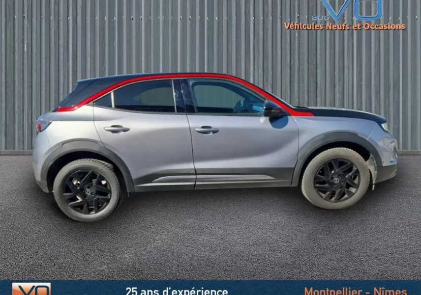 Profil droit d'un Opel Mokka gris clair 2022 avec toit rouge et jantes alliage noires de 18 pouces.