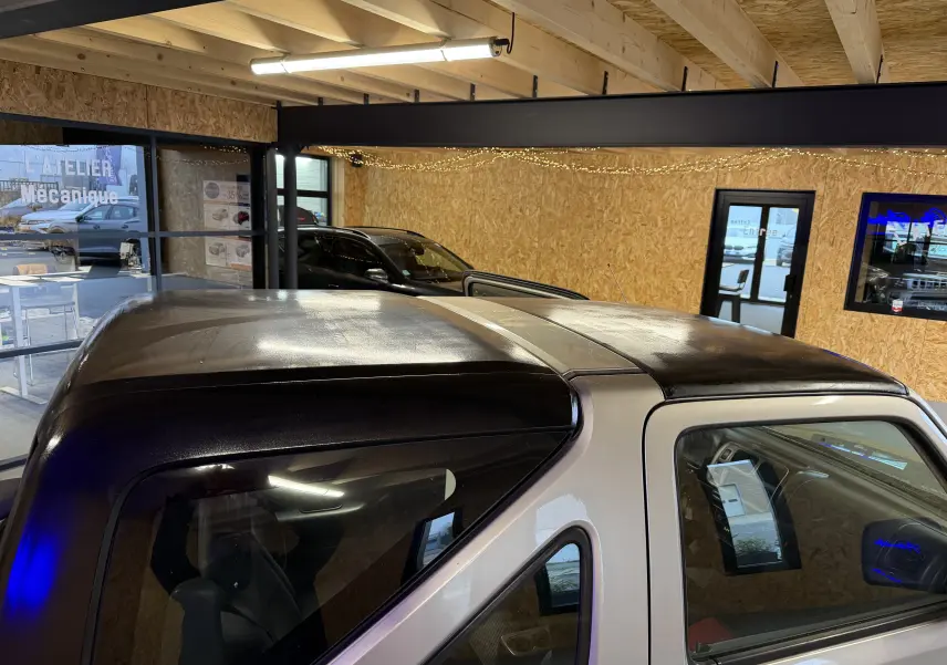 Vue rapprochée du toit hard-top noir et de la carrosserie grise du Suzuki Jimny Cabriolet 2005, côté gauche.