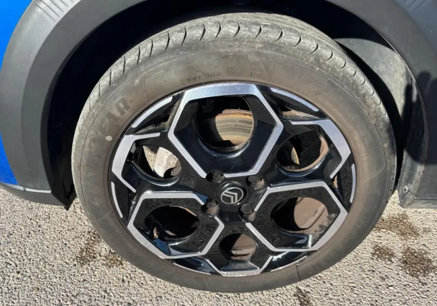 Gros plan sur la jante alliage 17 pouces noire et argentée du côté avant gauche d'une Citroën C3 bleu 2025.