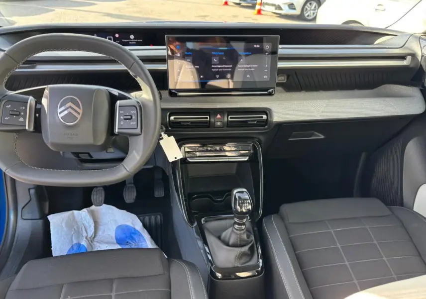 Vue intérieure avant du tableau de bord et volant de la Citroën C3 2025 avec boîte manuelle et écran tactile central.