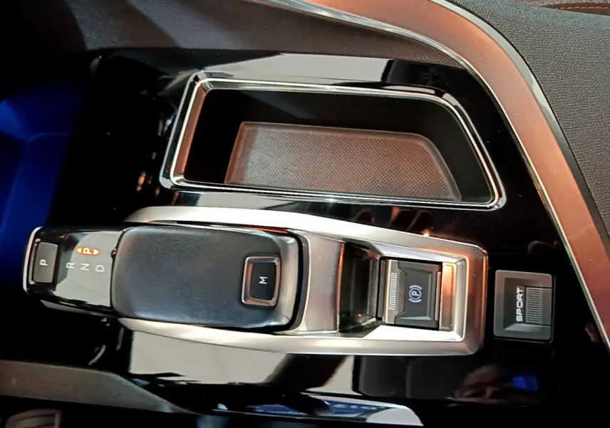 Gros plan sur la console centrale noire brillante du Peugeot 3008 2020 avec levier de vitesse automatique et bouton sport.