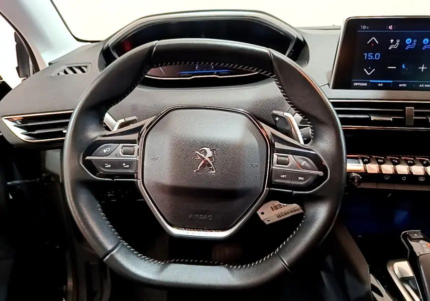 Vue rapprochée du volant cuir noir du Peugeot 3008 2020 avec tableau de bord numérique et écran tactile central.