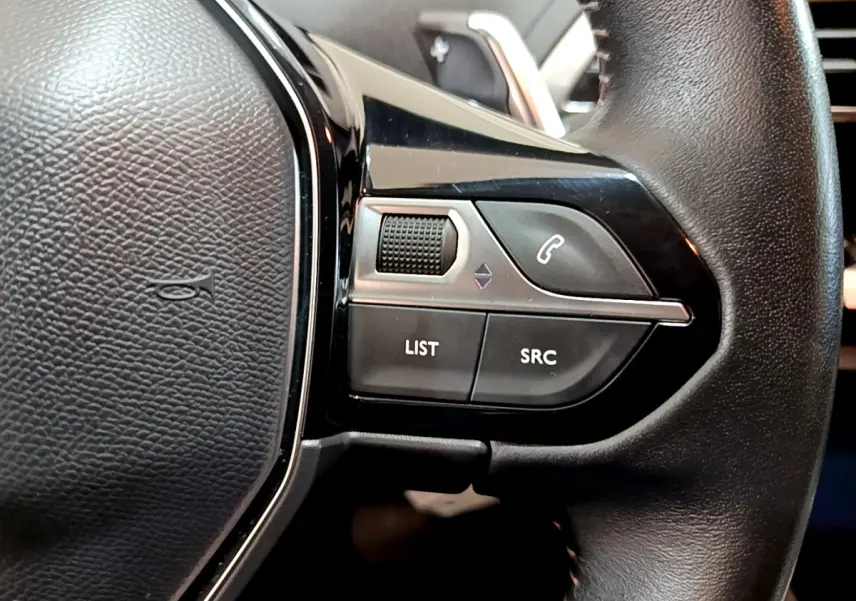 Gros plan sur les commandes droite du volant cuir du Peugeot 3008 gris foncé, boutons appel et audio visibles.