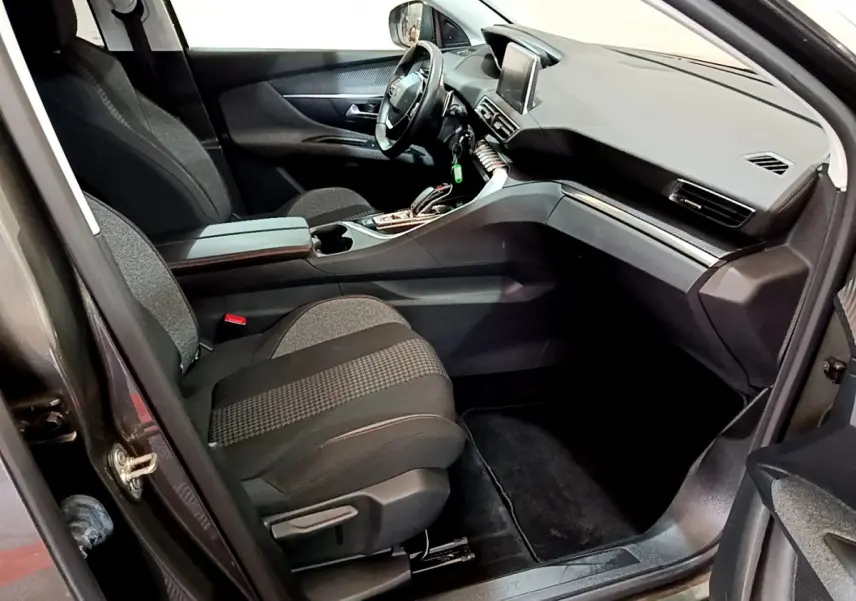 Intérieur avant droit du Peugeot 3008 gris foncé 2020, avec tableau de bord moderne et écran tactile central visible.