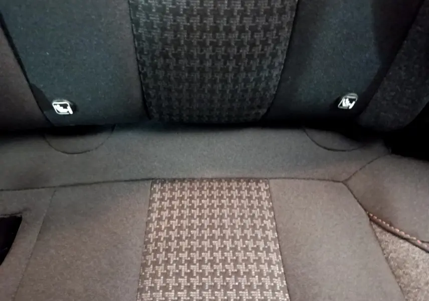 Gros plan sur la banquette arrière en tissu gris foncé du Peugeot 3008, montrant les attaches Isofix intégrées.