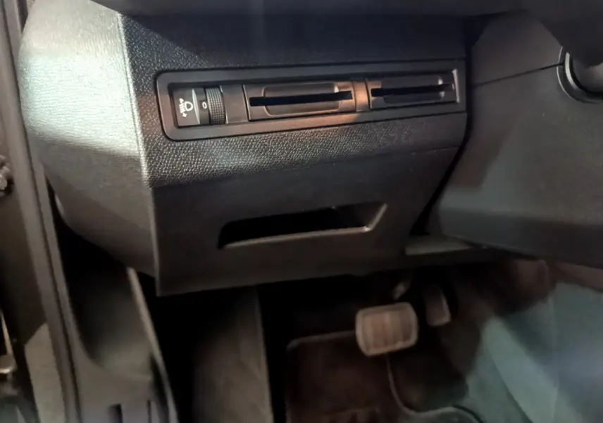 Détail du panneau de réglage des phares et des pédales côté gauche dans l'habitacle noir du Peugeot 3008 gris foncé