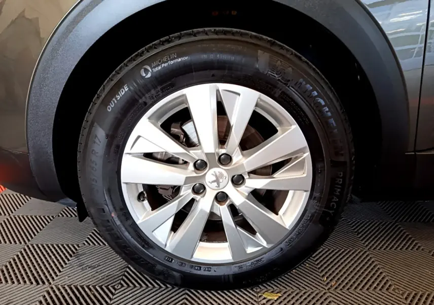 Gros plan sur la roue avant droite du Peugeot 3008 gris foncé, avec jante alliage et pneu Michelin.