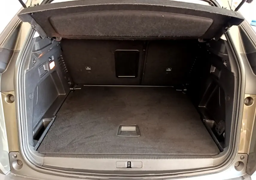 Coffre ouvert du Peugeot 3008 gris foncé, vue arrière montrant l'espace de chargement et la tablette cache-bagages.
