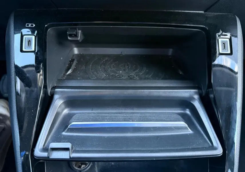 Gros plan sur le compartiment de rangement central noir du Peugeot 208 Hybrid 110 e-DCS6 Allure 2024 avec ports USB visibles.