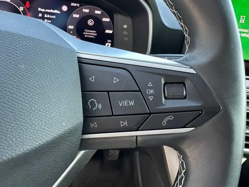 Gros plan sur les commandes multifonctions à droite du volant du SEAT LEON ST 2.0 TDI 115ch STYLE XL, intérieur noir.
