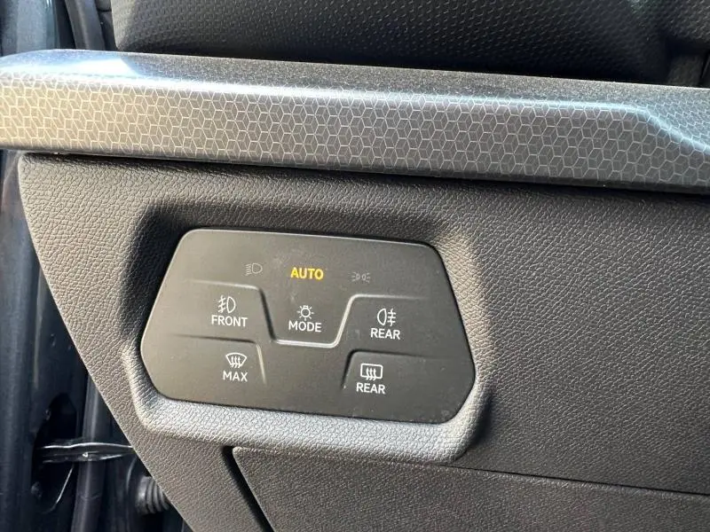 Détail du panneau de commande des feux avec mode automatique activé dans une SEAT LEON ST 2025 gris métallisé.