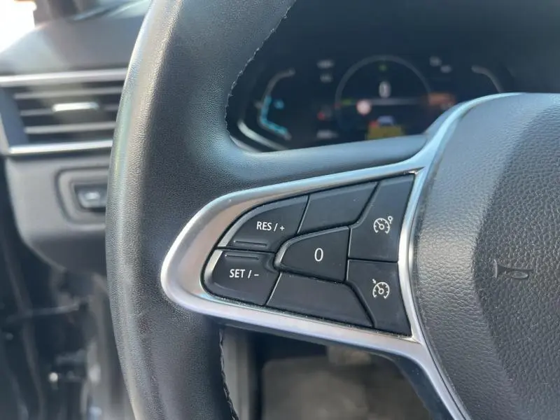 Gros plan sur les commandes de régulateur de vitesse au volant d'une Renault Clio gris Titanium 2021.