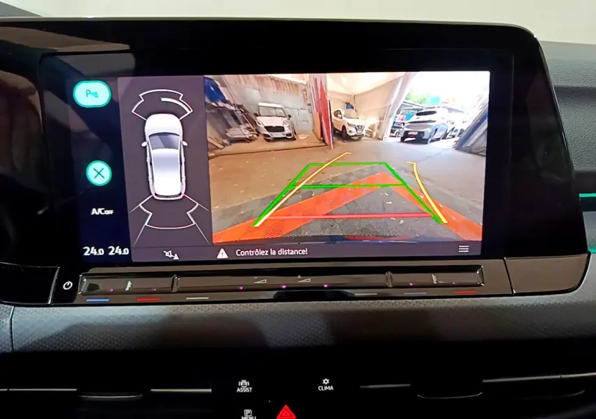 Écran tactile central de la Volkswagen Golf 2022 affichant la caméra de recul avec guidage coloré en intérieur de garage.