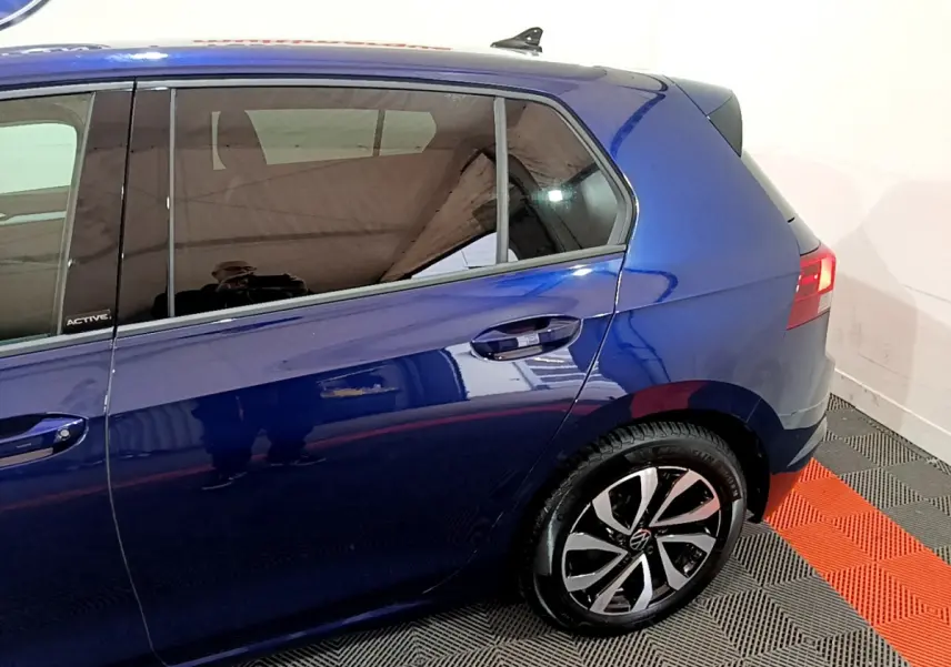 Vue latérale côté droit d'une Volkswagen Golf 1.0 TSI Active bleu avec jante alliage et vitres teintées.