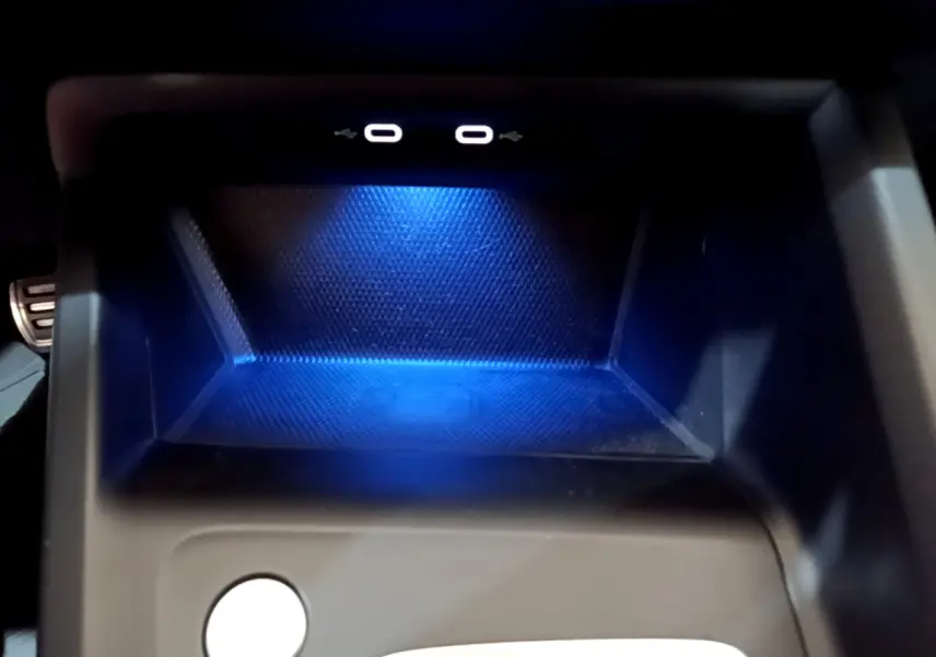 Gros plan sur la zone de recharge à induction bleutée avec deux ports USB-C dans une Volkswagen Golf 2022.