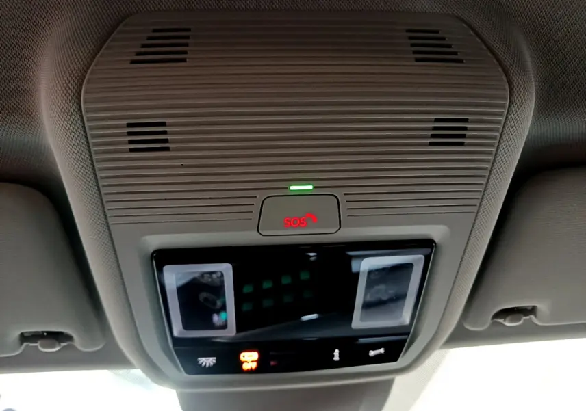 Vue en gros plan du plafonnier beige avec bouton SOS rouge et éclairage intérieur d'une Volkswagen Golf bleue 2022