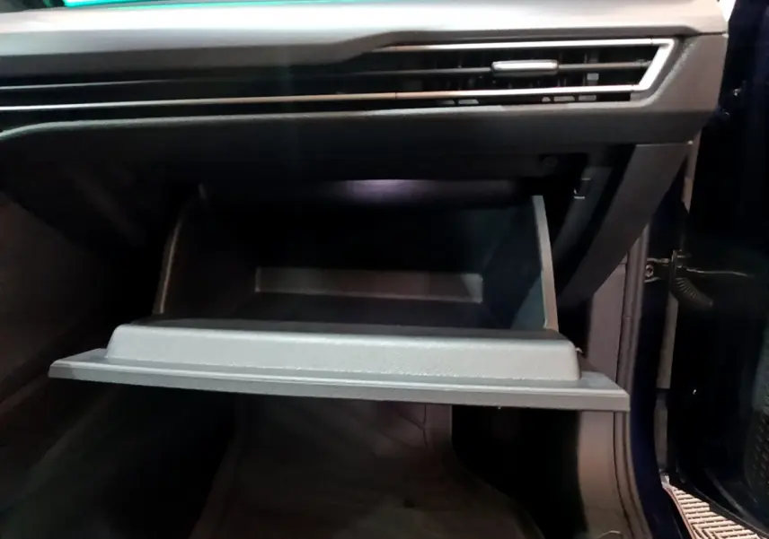 Gros plan sur la boîte à gants ouverte côté passager d'une Volkswagen Golf 1.0 TSI bleu 2022.