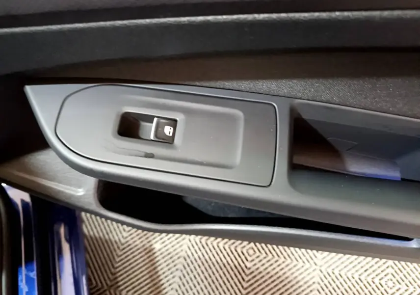 Gros plan sur la commande de verrouillage des portes côté gauche d'une Volkswagen Golf bleue 2022.